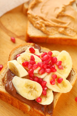 Sandwich of peanut butter, chocolate spread, bananas and pomegranate seeds