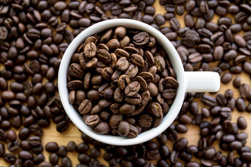 Close up of white coffee cup full of coffee beans background with copy space