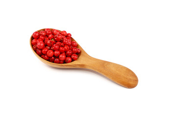 Wooden scoop spoon full of pink peppercorns