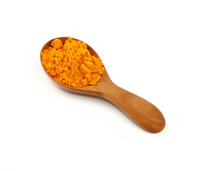 Wooden scoop spoon full of yellow turmeric powder