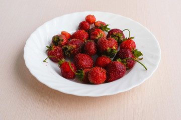 Juicy appetizing tasty strawberry on a white plate.