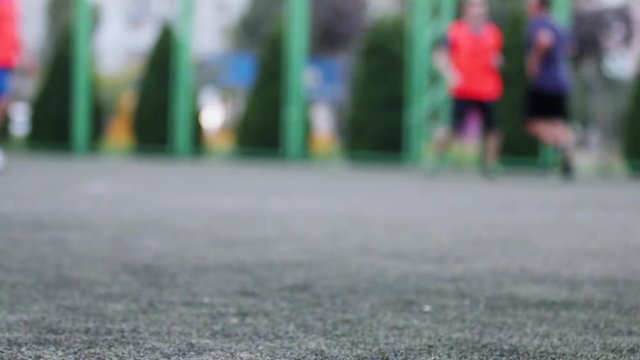 Close up aut focus of men`s feet playing and running through football  field in the city park. Shallow depth of the field, toned video, 50fps.