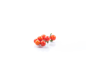 small ripe red cherry tomatoes on a branch