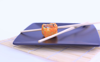 close-up of sushi and chopsticks on a black plate