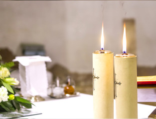 two candles illuminate the altar of the church for Holy Mass