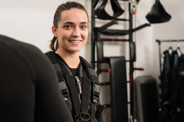 Happy young woman wearing electro muscular stimulation vest