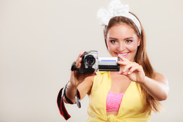 Happy pin up girl woman filming with camcorder.