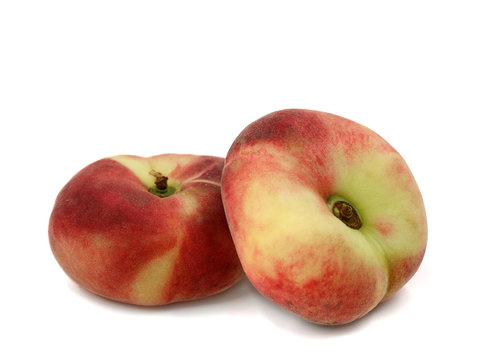 Prunus Persica, two flat peaches isolated on a white background