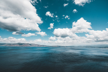 Obraz premium Panoramic view of rocks and beach with sky and clouds in Crete, Greece. Amazing scenery with crystal clear water and the rock formation against a deep blue sky during Summer period. Greece, Europe