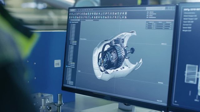 Close-up Shot of the 3D CAD Model of the Engine Shown on Computer Screen. In the Background Manufacturing Factory with People Working. Shot on RED EPIC-W 8K Helium Cinema Camera.