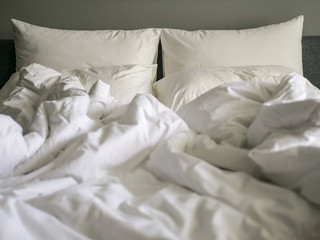 lazy Sunday morning with crumpled white bed sheet 