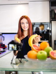 Young woman blogging and prepare fruit mix