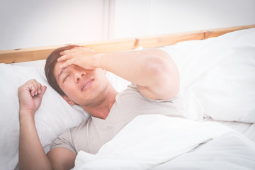 Sleepless hangover man on bed woke up with headache