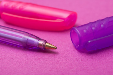 closeup of colorful ballpoint pens on color background