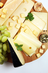 Cheese platter with different cheese and grapes.