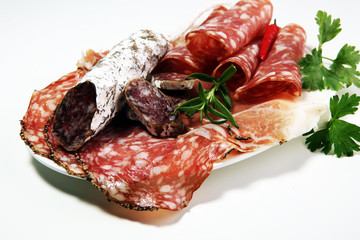 Food tray with delicious salami, ham,  fresh sausages and herbs. Meat platter with selection