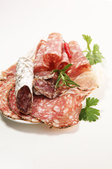 Food tray with delicious salami, ham,  fresh sausages and herbs. Meat platter with selection