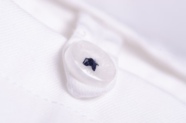 Obraz na płótnie Canvas White shirt material fabric fashion button macro blur background