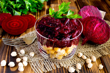 Vegetarian salad with chickpea and beet  in the glass jar on the  rustic wooden   background