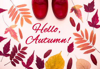 Multicolored autumn leaves frame and red rubber boots. Hello, Autumn words