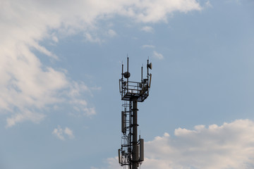 Telecommunications tower with blue sky and clouds