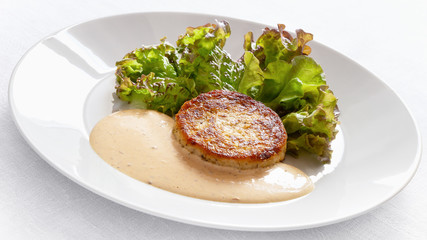 fried cabbage cutlet on lettuce leafs with adjika based sauce