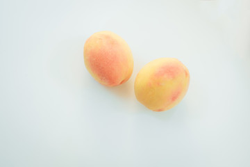 Two peaches on a light background