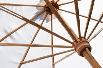 Under view of wooden umbrella with white cover, texture of umbrella shape.