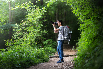 young asian smart backpacker photographer or hotography trek with backpack and camera for take a...