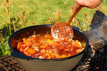 Roasting meat for cooking pilaf in vegetable oil on picnic