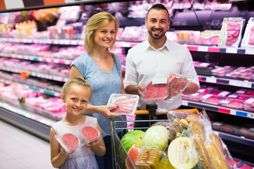 Family buying meat in supermarket.