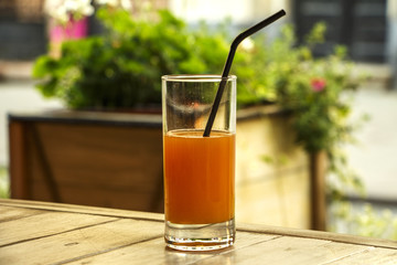 Fresh orange juice with mint in a glass bowl on a dark plate. Orange juice on a dark background, top view, copy space.