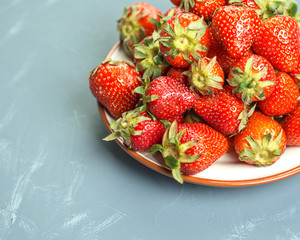 Plate with strawberries on a light-blue background