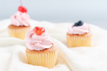 Group of cupcakes arrange on long white plate on table with blur background, dessert bakery in minimal concept.  Bakery advertise in menu.