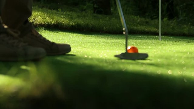 Perfect golf putt. Three orange balls