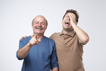Two friends in casual colorful wear standing and laughing together. Best friends enjoying life. Two...