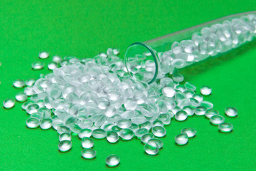 Transparent Polyethylene granules on a green background.The concept of free bpa. HDPE Plastic pellets.  Plastic Raw material . IDPE.