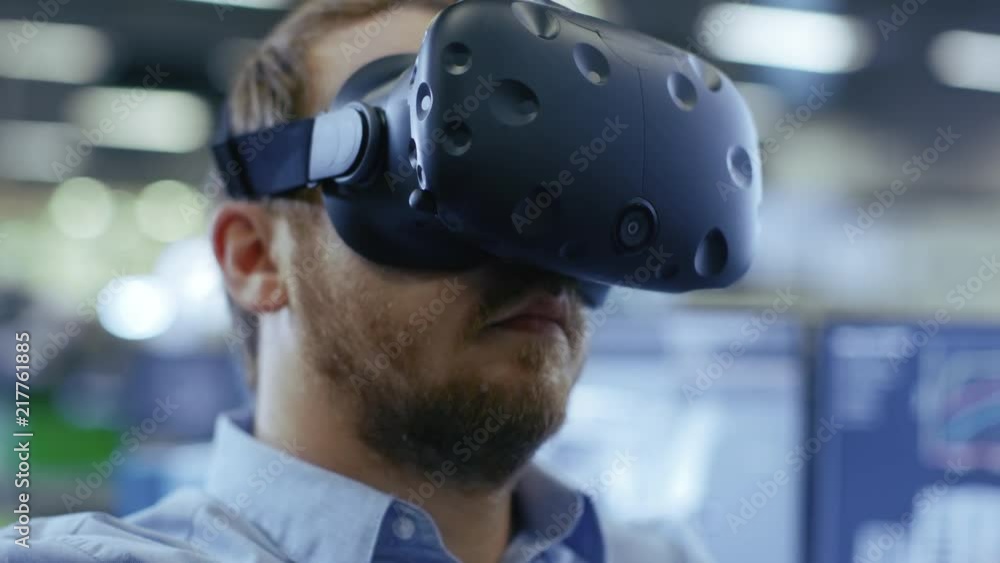 Poster portrait shot of the industrial engineer wearing virtual reality headset and gesturing with controll