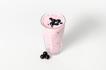 Fototapeta na wymiar Glass of yoghurt cocktail, smoothies, with berry of black currant, stands on a white background.