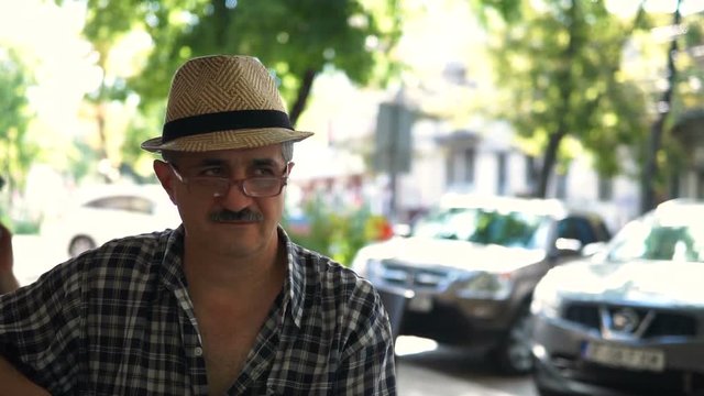 Outdoor portrait of smiling man in hat