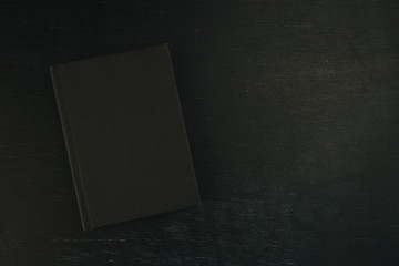 Top view flat lay black notebook on dark background
