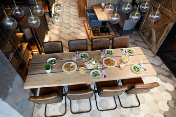 Tasty pizza, vegetable salad, chips, crispy bread, jam and lemonade on wooden table waiting for guests