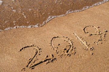 beach and 2018 written in sand close up