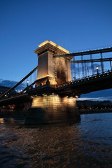 Obraz premium Panoramiczne widoki na nocne mosty przez Dunaj z oświetleniem.