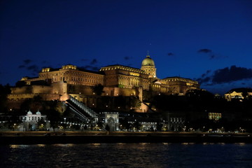 Fototapeta na wymiar Panoramic view of the palace with illumination of walls from Danube at night.