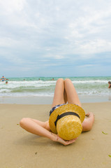 Young girl with yellow hat on the beach in the summer season