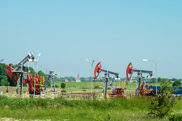 Fototapeta na wymiar Oil and gas industry. Work of oil pump jack on a field.