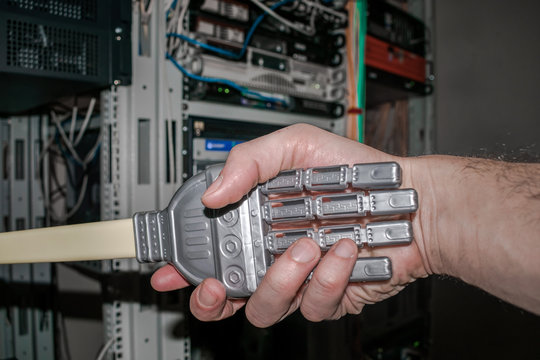 Handshake of man and robot. The concept of friendship between man and machine. The hand of the person and the robot on the background of the servent room of the data center