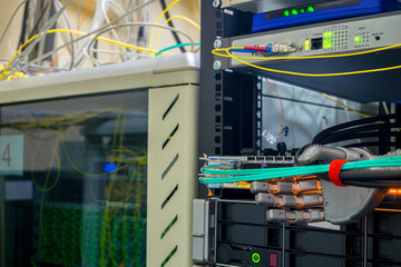 An artificial metal arm performs work in the server room. The robot switches the wires in the data...