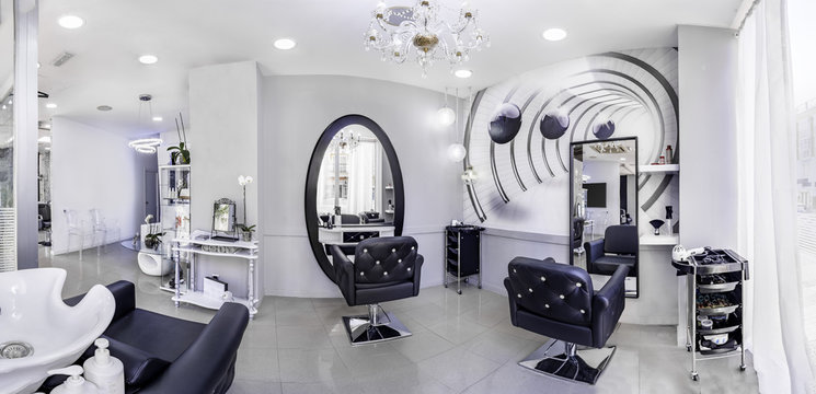 Panorama of a  modern bright beauty salon. Hair salon interior business with black and white luxury decor.